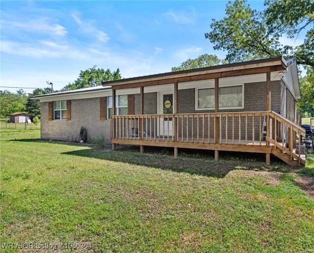 back of house featuring a wooden deck and a yard