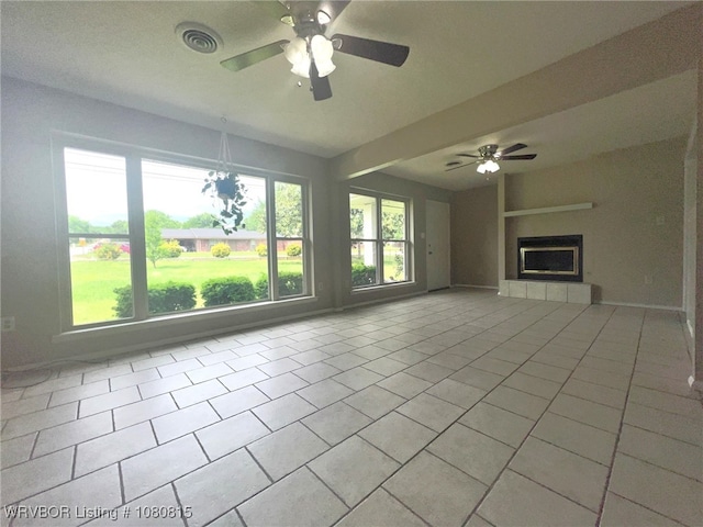 unfurnished living room featuring light tile patterned floors, visible vents, a fireplace, and ceiling fan