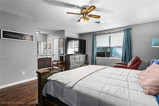 bedroom with visible vents, dark wood-type flooring, a textured ceiling, baseboards, and a textured wall