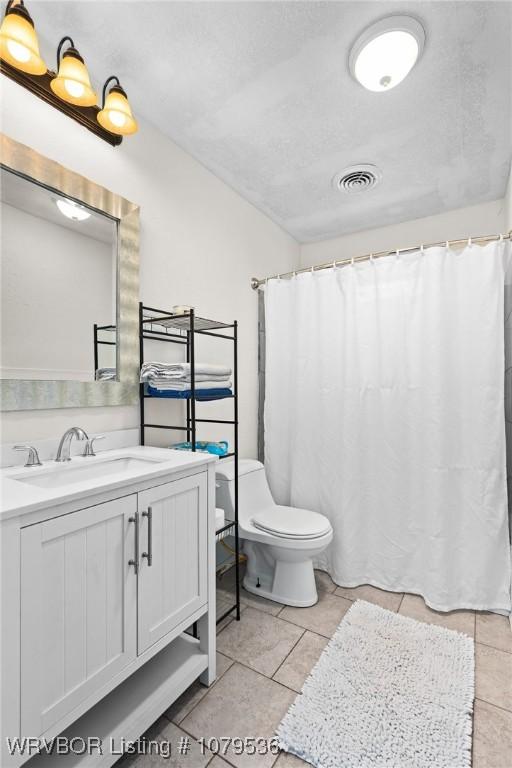 bathroom with visible vents, curtained shower, toilet, and vanity