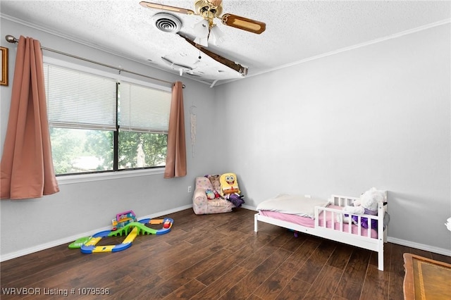 bedroom with ceiling fan, wood finished floors, baseboards, and a textured ceiling