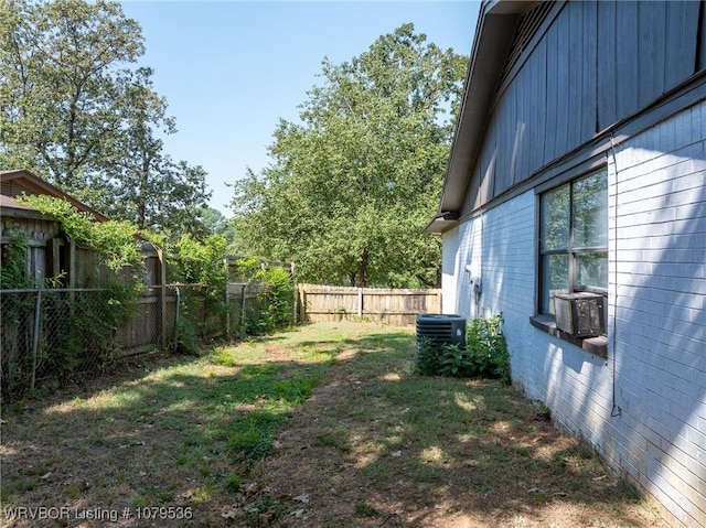 view of yard with cooling unit, central AC, and a fenced backyard