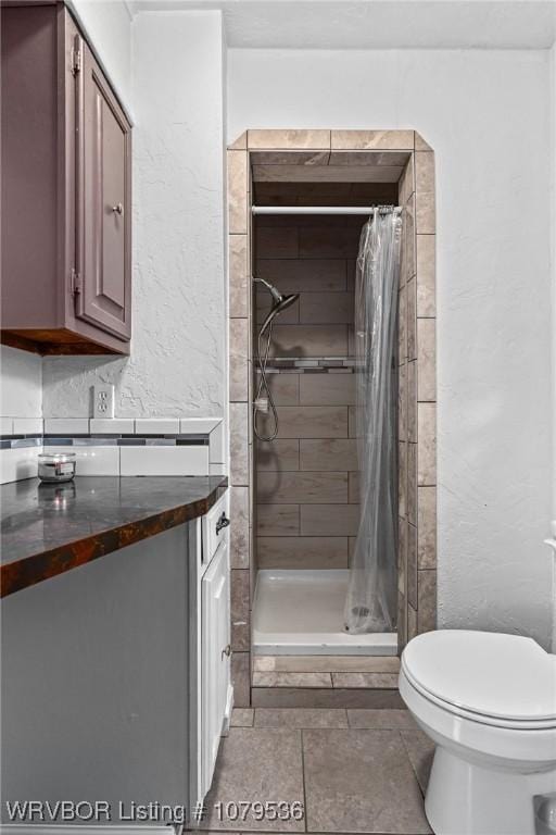 full bathroom with a shower stall, toilet, and a textured wall