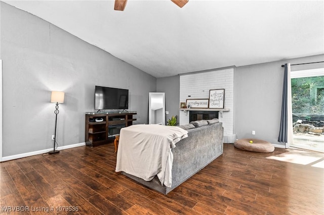 living area with baseboards, a ceiling fan, lofted ceiling, and wood-type flooring