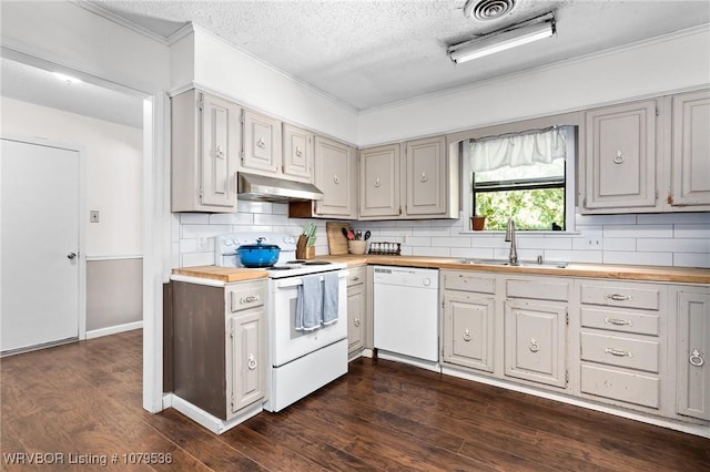 kitchen with white appliances, dark wood finished floors, a sink, under cabinet range hood, and wood counters