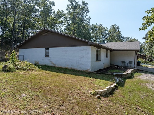 view of home's exterior featuring brick siding and a lawn