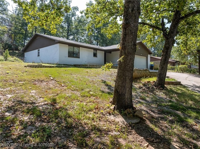 ranch-style home featuring a front lawn and a garage