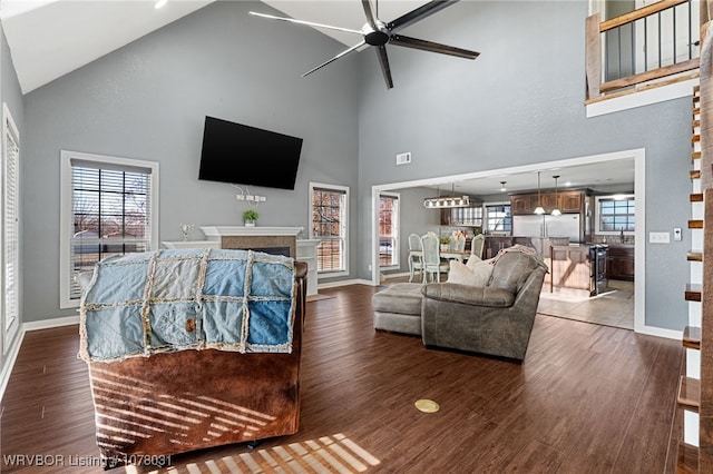 living room with ceiling fan, high vaulted ceiling, and dark hardwood / wood-style floors