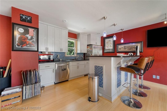 4110 S 34th St, Fort Smith, AR 72903 - kitchen with stainless steel appliances, dark countertops, light wood-style floors, and white cabinetry