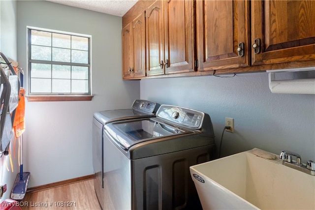 3001 Coral Cir, Alma, AR 72921 - laundry area with independent washer and dryer, cabinet space, light wood finished floors, baseboards, and a textured ceiling