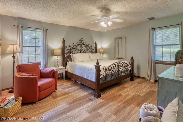 3001 Coral Cir, Alma, AR 72921 - bedroom with a textured ceiling, light wood finished floors, ceiling fan, and baseboards