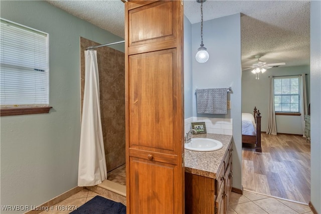 3001 Coral Cir, Alma, AR 72921 - ensuite bathroom featuring a textured ceiling, tile patterned floors, tiled shower, vanity, and ceiling fan