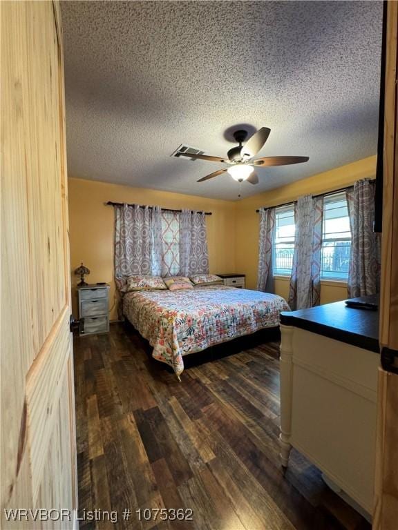 bedroom featuring a textured ceiling, ceiling fan, and dark hardwood / wood-style floors