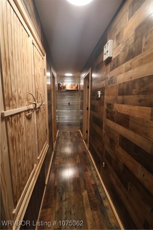 hallway with wood walls and dark hardwood / wood-style flooring