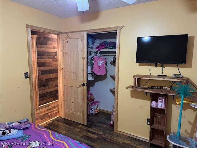 bedroom with a textured ceiling, dark hardwood / wood-style floors, and ceiling fan