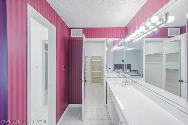 bathroom with tile patterned floors, vanity, wallpapered walls, and visible vents