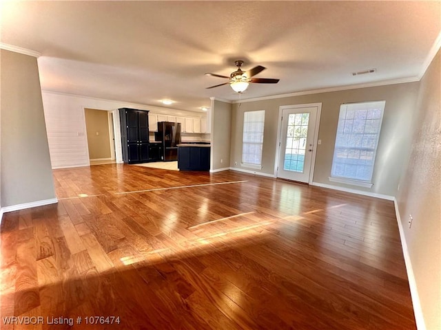 unfurnished living room with dark hardwood / wood-style flooring, crown molding, and ceiling fan