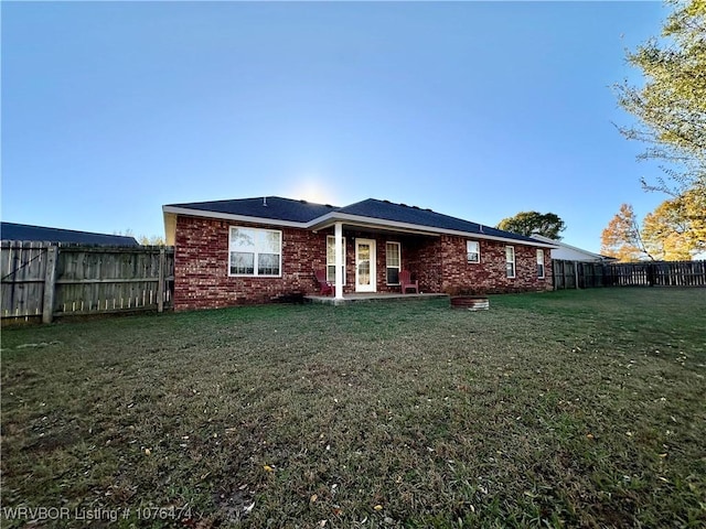 rear view of property with a lawn