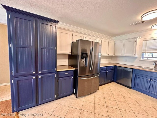 kitchen with appliances with stainless steel finishes, ornamental molding, blue cabinets, sink, and white cabinets