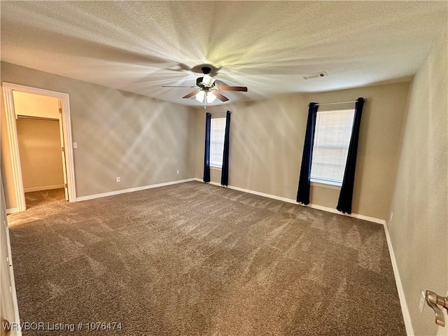 carpeted spare room featuring ceiling fan and a textured ceiling