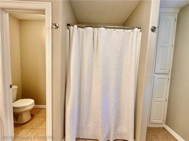 bathroom with toilet and tile patterned floors