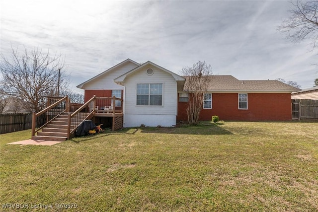 back of house featuring a wooden deck, a yard, and fence