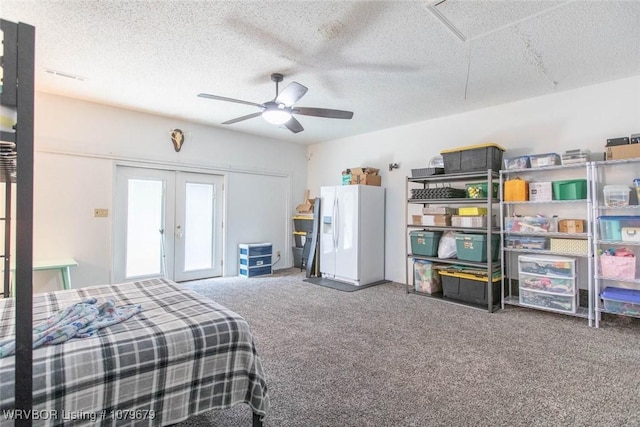 carpeted bedroom featuring french doors, a textured ceiling, white refrigerator with ice dispenser, and a ceiling fan