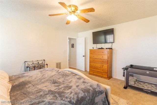 bedroom with visible vents, carpet flooring, a textured ceiling, and ceiling fan
