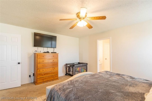 carpeted bedroom with ceiling fan and a textured ceiling