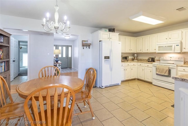 kitchen with visible vents, light stone counters, white appliances, a chandelier, and hanging light fixtures