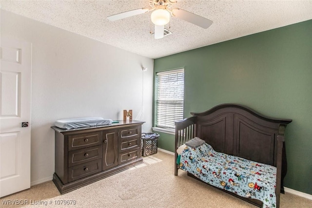 bedroom with light carpet, ceiling fan, a textured ceiling, and baseboards