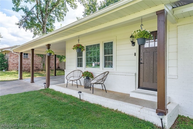 1723 N 52nd St, Fort Smith, AR 72904 - view of exterior entry featuring covered porch, a lawn, and brick siding