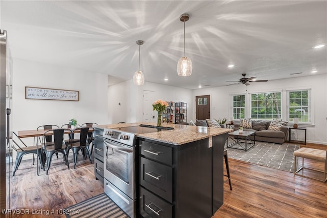 1723 N 52nd St, Fort Smith, AR 72904 - kitchen featuring electric stove, wood finished floors, dark cabinets, a kitchen bar, and a ceiling fan