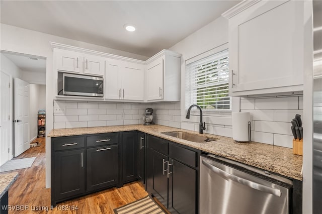1723 N 52nd St, Fort Smith, AR 72904 - kitchen with appliances with stainless steel finishes, white cabinetry, light stone counters, and backsplash