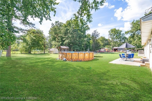1723 N 52nd St, Fort Smith, AR 72904 - view of grassy yard with a patio area, an outdoor pool, and a storage shed