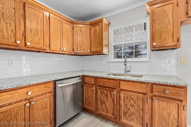 kitchen featuring tasteful backsplash, light hardwood / wood-style floors, stainless steel dishwasher, sink, and light stone countertops