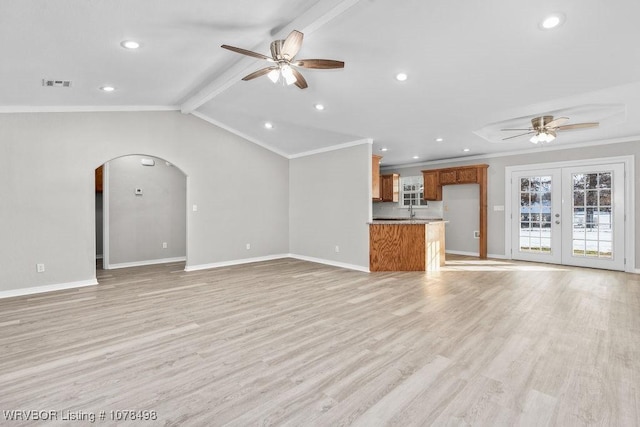 unfurnished living room with french doors, lofted ceiling with beams, light wood-type flooring, ceiling fan, and crown molding