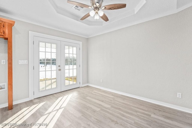 unfurnished room featuring french doors, ornamental molding, light hardwood / wood-style flooring, and a raised ceiling