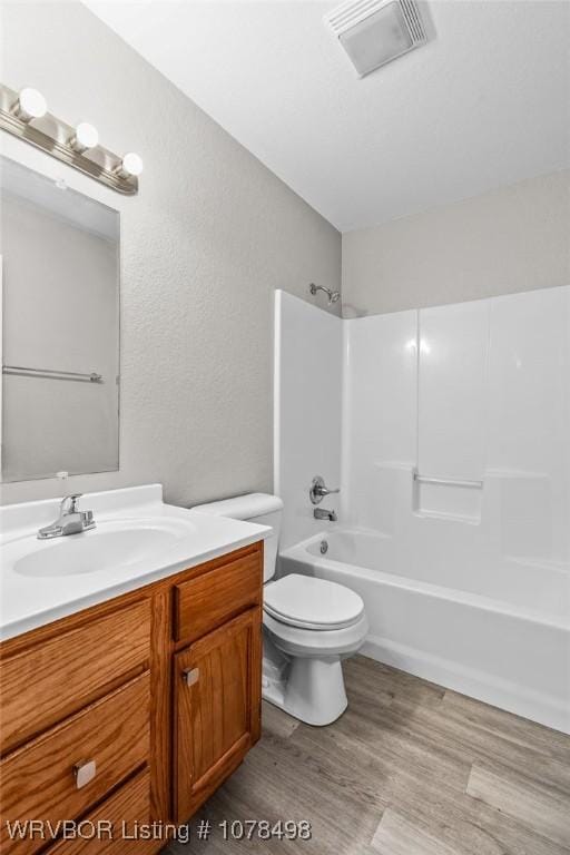 full bathroom featuring toilet, wood-type flooring, vanity, and bathtub / shower combination