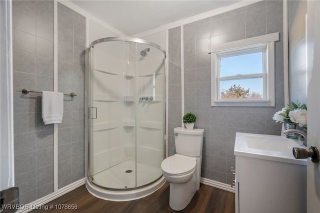 bathroom with wood-type flooring, toilet, vanity, and walk in shower