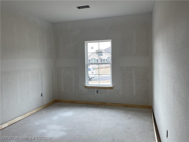 unfurnished room with concrete flooring