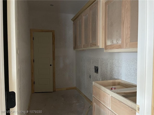 laundry area featuring cabinet space and baseboards