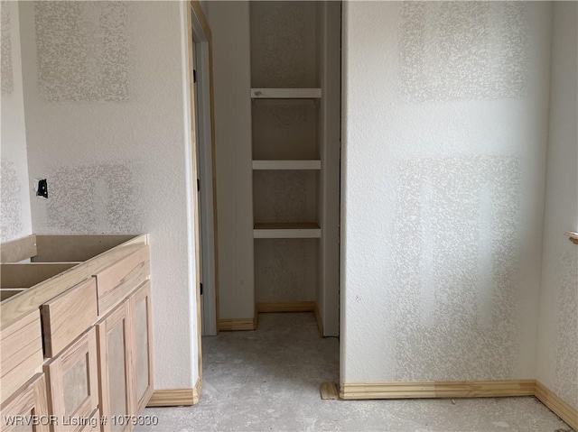 bathroom featuring baseboards, built in features, and a textured wall