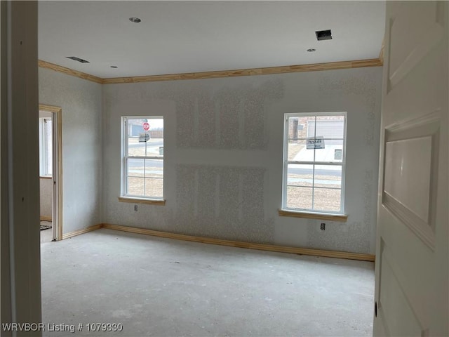 spare room featuring baseboards, unfinished concrete floors, visible vents, and crown molding