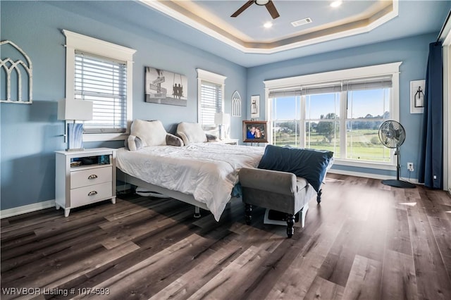 bedroom featuring ceiling fan, dark hardwood / wood-style floors, and a raised ceiling