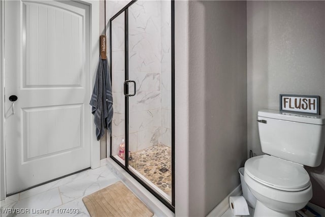 bathroom featuring toilet and a shower with door