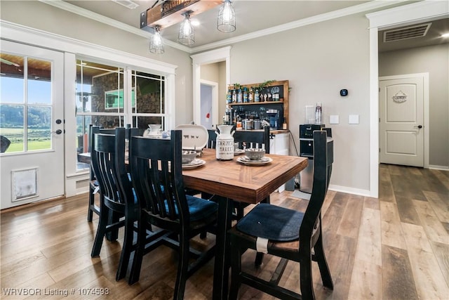 dining room featuring wood-type flooring and ornamental molding