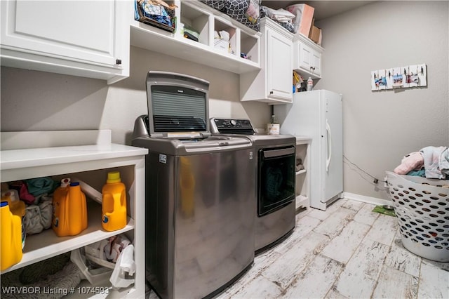 washroom with cabinets and independent washer and dryer