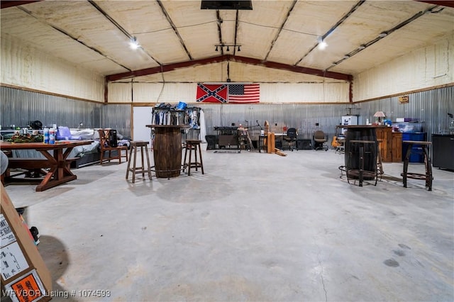 miscellaneous room featuring lofted ceiling and concrete flooring