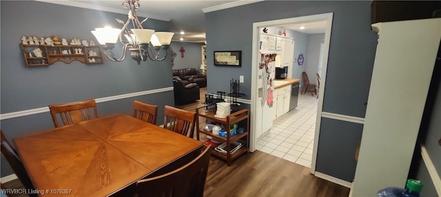 dining space featuring dark wood-type flooring, crown molding, and a notable chandelier